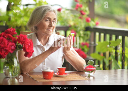 Portrait Of Happy gealterte Frau Reden auf dem Smartphone Stockfoto