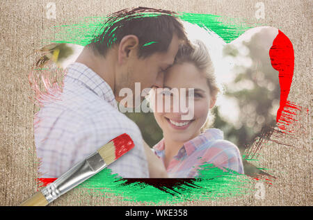 Das zusammengesetzte Bild der glücklichen Paare in der Landschaft gegen die verwitterte Oberfläche mit Pinsel Stockfoto