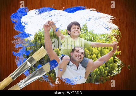 Das zusammengesetzte Bild von Vater und Sohn in den Park gegen Oberfläche mit Pinsel Stockfoto