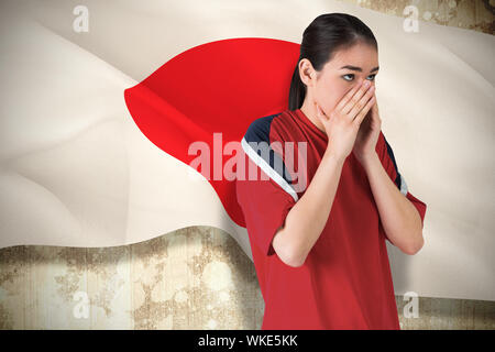 Das zusammengesetzte Bild der nervösen Fußballfan nach vorn gegen Japan Flagge Stockfoto