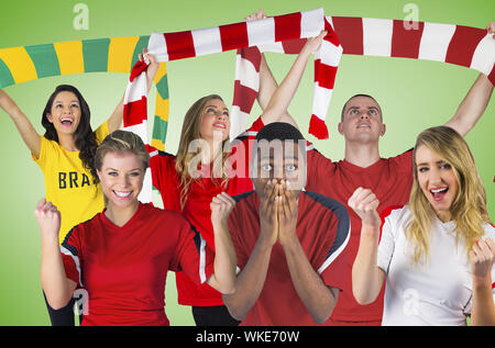 Das zusammengesetzte Bild der Fußballfans gegen grüne Vignette Stockfoto