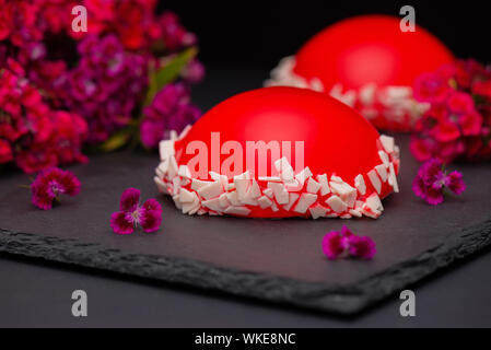 Rote Erdbeere Glasur Mousse Cake, auf dunklem Hintergrund, Nahaufnahme. Rote Kuchen mit Spiegel Glasur. Stockfoto