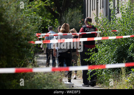 Berlin, Deutschland. 04 Sep, 2019. Polizisten zu Fuß nicht weit von einem Haus am Bruno-Taut-Ring in Neukölln. Ein 40-jähriger Mann war es angegriffen und tödlich verletzt. Die Blut-getränkten Mann wurde am Mittwoch Morgen vor einem Haus auf Bruno Taut Ring gefunden und starb wenig später im Krankenhaus, Polizei gemeldet. Credit: Paul Zinken/dpa/Alamy leben Nachrichten Stockfoto