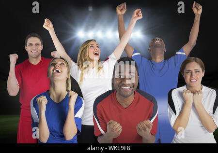 Das zusammengesetzte Bild von verschiedenen Fußball-Fans gegen Fußballplatz unter Strahler Stockfoto