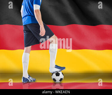 Das zusammengesetzte Bild im Fußball Spieler mit Ball gegen digital erzeugten deutschen Nationalflagge Stockfoto