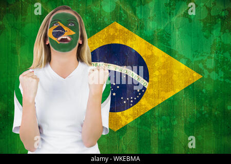 Aufgeregt Brasil in Gesicht Farbe Jubel gegen Brasilien Flagge im grunge Effekt Stockfoto