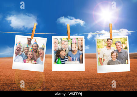 Das zusammengesetzte Bild von Instant Fotos hängen an einer Linie gegen das Feld und blauer Himmel Stockfoto