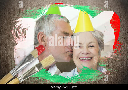 Das zusammengesetzte Bild im Senior Paar feiert Geburtstag mit Pinsel gegen die verwitterte Oberfläche Stockfoto