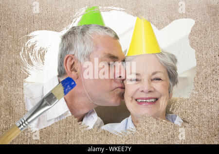 Das zusammengesetzte Bild im Senior Paar feiert Geburtstag mit Pinsel eingetaucht in Blau gegen die verwitterte Oberfläche Stockfoto