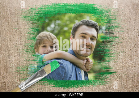 Das zusammengesetzte Bild von Vater und Sohn in den Park mit Pinsel eingetaucht in Grün gegen die verwitterte Oberfläche Stockfoto