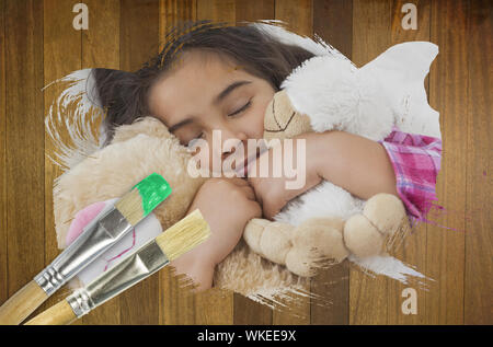Das zusammengesetzte Bild des kleinen Mädchens teddys Schmusen mit Pinsel gegen Holz- Oberfläche mit Planken Stockfoto