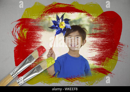 Das zusammengesetzte Bild im kleinen Jungen mit Windrad mit Paintbrush eingetaucht in Gelb gegen digital erzeugten grauer Hintergrund