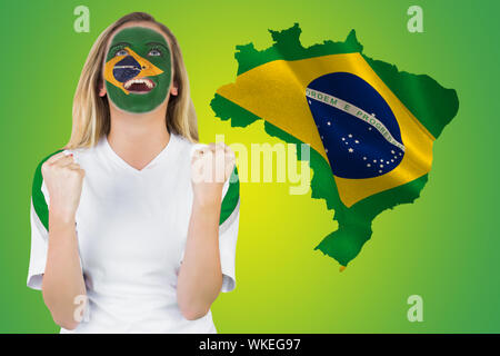 Aufgeregt Brasil in Gesicht Farbe Jubel gegen Grün mit Flagge Brasilien Stockfoto