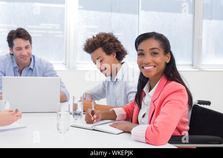 Attraktive Geschäftsfrau lächelt in die Kamera während einer Konferenz Stockfoto