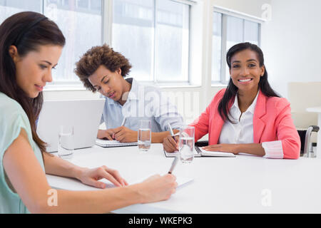Attraktive Geschäftsfrau lächelt in die Kamera während einer Konferenz Stockfoto