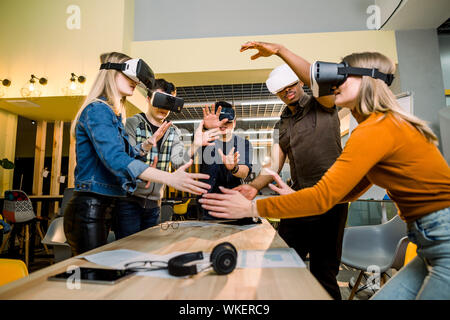 Junge multirassischen Business Leute mit Virtual reality Brillen mit berühren Luft während der VR-Konferenz Konferenz im Büro. Business Männer und Frauen Stockfoto