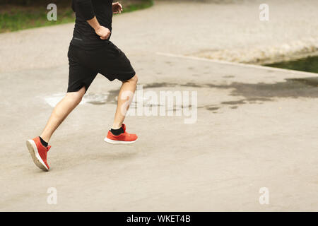Nicht erkennbare männliche Läufer in rote Turnschuhe Jogging im Freien Stockfoto