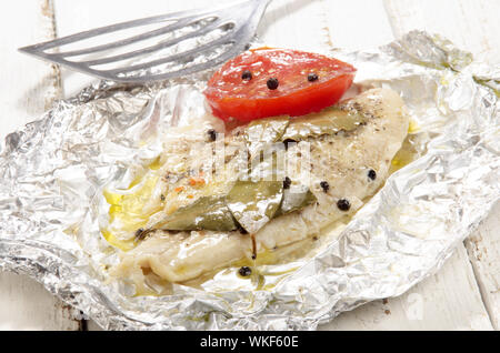 gebackener Pangasius mit Paprika und Tomaten in Alufolie Stockfoto