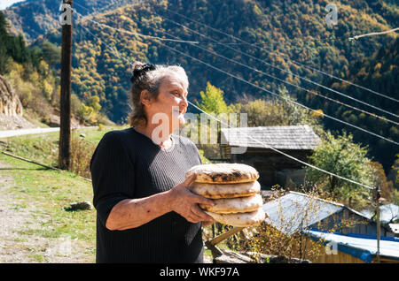 Mestia, Samegrelo-Zemo obere Swanetien, Georgien - 18. Oktober 2016: Alte Frau hält eine traditionelle georgische Brot Stockfoto