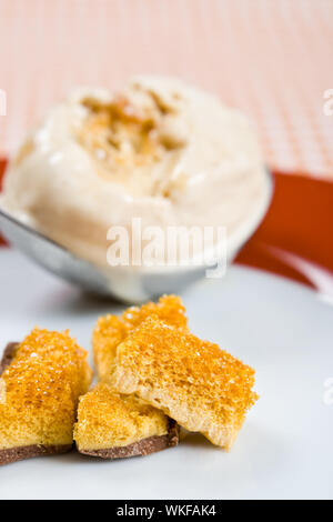 Waben Sie mit einer Kugel Toffee Eis auf einem Teller Stockfoto