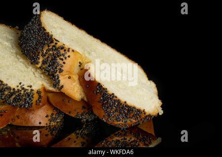 Nahaufnahme von drei Schichten von twisted Mohn Brötchen auf schwarzem Glas isoliert Stockfoto