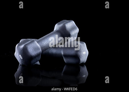 1 kg Hanteln für Krafttraining auf schwarzem Hintergrund. Stockfoto