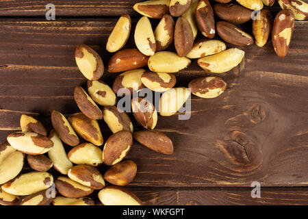 Menge ganze rohe braun Brasilien Mutter flatlay auf braunem Holz Stockfoto