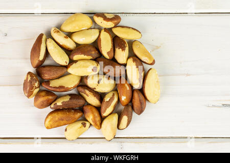 Menge ganze rohe braun Brasilien Mutter flatlay auf weißem Holz Stockfoto