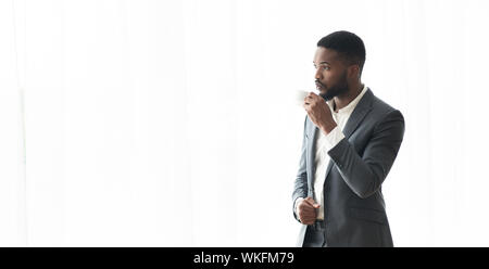 Nachdenklich Afrikanische amerikanische Geschäftsmann genießen Cityview aus dem Fenster im Büro Stockfoto