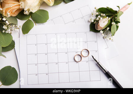Trauringe die Wahl des Datums in Papier Kalender Stockfoto