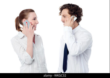 Junge Kolleginnen und Kollegen über Handy kommunizieren Stockfoto