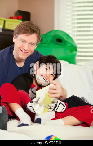 Schönen Vater spielen Autos mit behinderten Sohn auf Bodenmatte Stockfoto