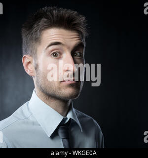 Elegante Jüngling Blick in die Kamera, die Überraschung zum Ausdruck zu bringen. Stockfoto