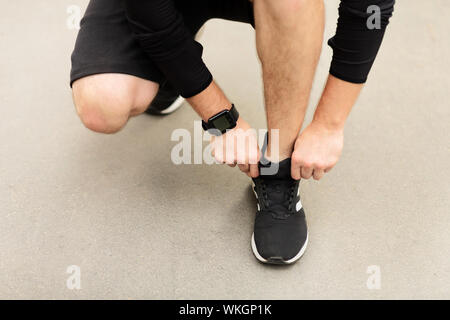 Männliche Athlet Schuhe zur Festsetzung vor dem Betrieb im Freien Stockfoto