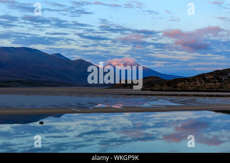 Die Aussicht von Durness über den Kyle von Durness bei Sonnenaufgang. Beinn Spionnaidh, die schneebedeckten Berge im Hintergrund begrenzt, beleuchtet von der aufgehenden Sonne. In der Stockfoto