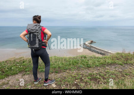 Reife weibliche Wanderer auf dem Cleveland Weise Coastal Trail mit Blick auf cattersty Sands Beach bei Skinningrove, North Yorkshire, England. Großbritannien Stockfoto