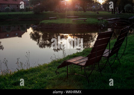 Zone Rest. Hölzerne Stühle stehen auf der Wiese am See, mit Blick auf den See. Weißrussland Stockfoto