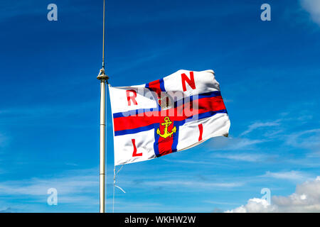 RNLI (Royal National Lifeboat Institution) Flagge im Wind flattern Stockfoto