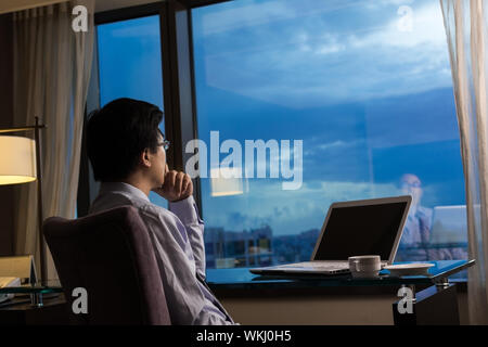 Asiatische Geschäftsmann in einem Raum sitzen und Blick in die Ferne, Konzept des Reisens Geschäft, träumen, arbeiten in der Nacht etc.. Stockfoto