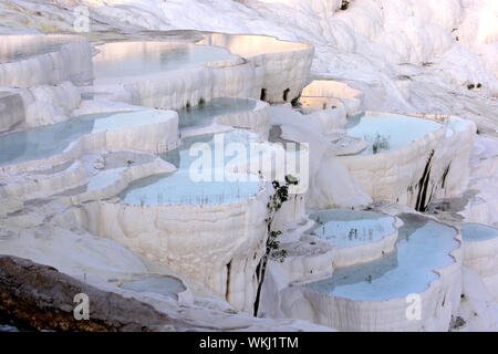 Die Sonne über dem spektakulärsten Abschnitt der Travertine (natürlichen Thermalbecken) bei Baumwolle Schloss bei Pamukkale in der Türkei. Stockfoto