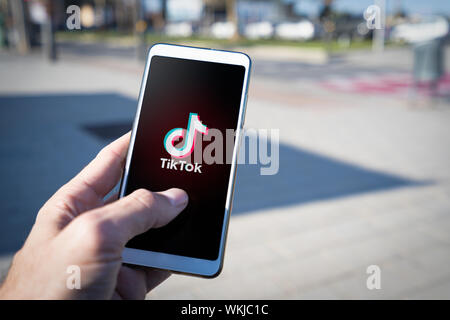 Barcelona, Spanien. September 2019: Mann hält ein Smartphone mit streaming Service Media und Video TikTok auf dem Bildschirm. Stockfoto
