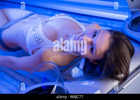 Attraktive Frau entspannen und Sonnenbaden im Solarium im Solarium. Stockfoto