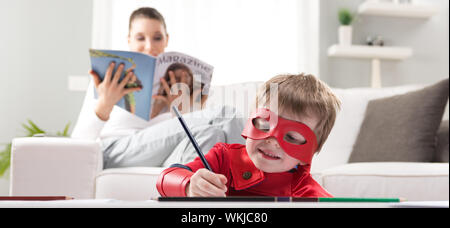 Niedliche Superhelden junge mit Mutter lesen auf Hintergrund gezeichnet. Stockfoto