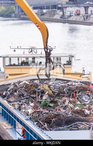 Offenen Schiff geladen oder in einem Kai auf einem städtischen Wasserstraße oder Fluss durch ein heavy-Duty Industriekran abgeladen Stockfoto