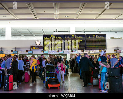VERSPÄTUNGEN AM FLUGHAFEN SCHLAGEN WARTEZEITEN bei Urlaubsreisen TUI Charterflüge Passagiere und Gepäck warten auf der Flughafenkonkurise, um ihre Flüge zu checken Lanzarote Spanien EU Stockfoto