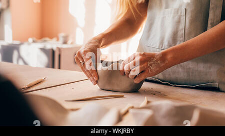 Nahaufnahme von Potter Hände formen ein Schüssel am Schreibtisch Stockfoto