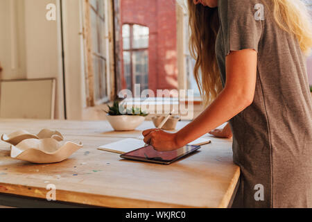 Seitenansicht des unkenntlich Keramikkunst Skizzieren auf digital Tablet am Schreibtisch Stockfoto