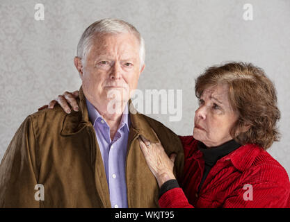 Betroffenen senior Mann und Frau auf grauem Hintergrund Stockfoto