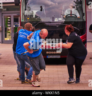 Wolfsburg, Deutschland, September 1., 2019: Team von fünf starke Männer ziehen in den Spaß-Meisterschaft wird durch eine leicht übergewichtige Frau in Bl jubelten Stockfoto