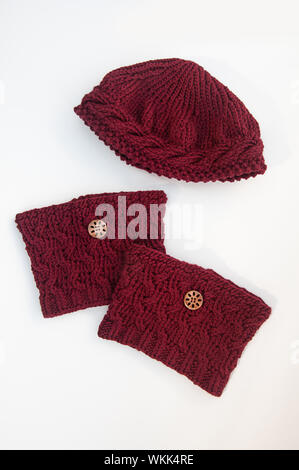 Mode Zubehör Set für Frauen Herbst und Winter Hut und boot Topper. Grob gestrickter wolle Hut und Stiefel Manschetten mit Holz Tasten auf einem leichten isoliert. Stockfoto